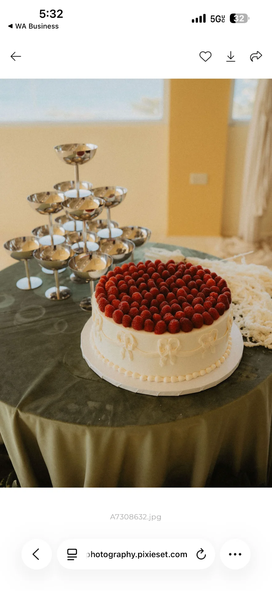 Bizcocho blanco decorado con frutos rojos en una mesa de recepción