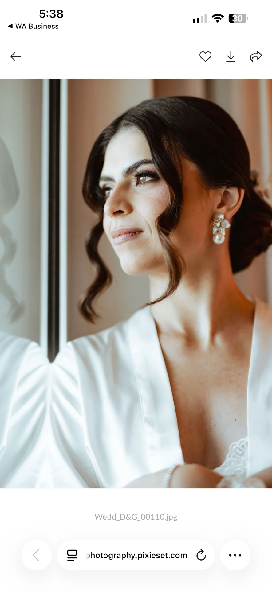 Retrato de la novia con bata blanca junto a la ventana