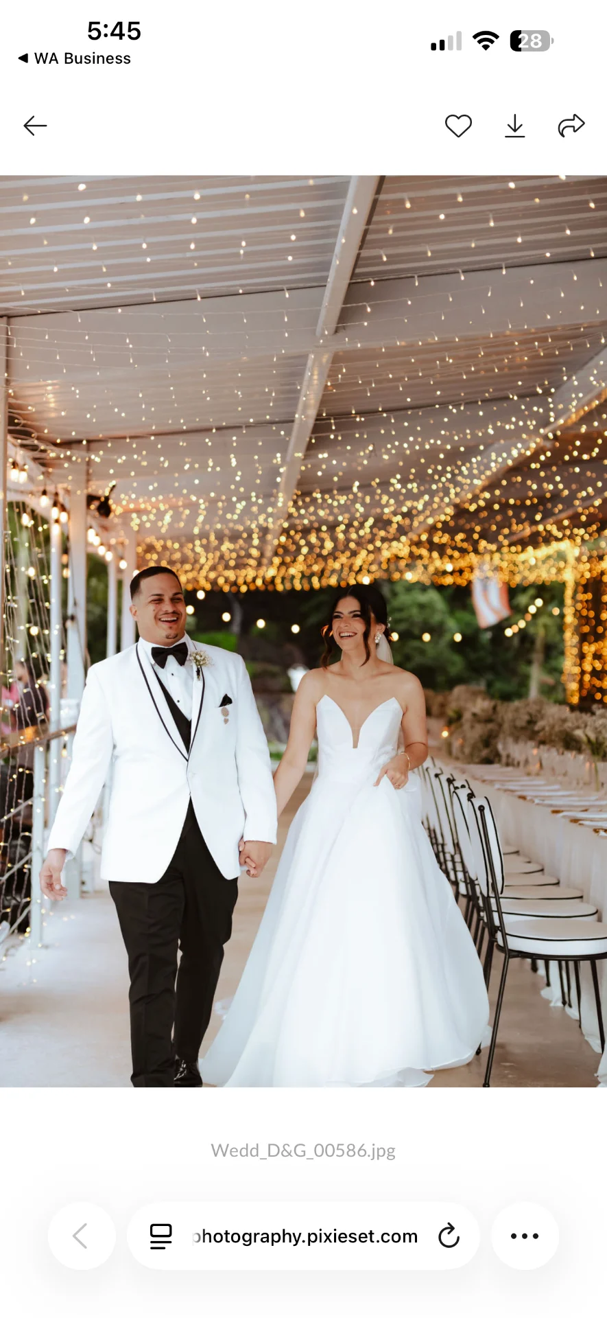Pareja entrando a la recepción bajo un techo de luces