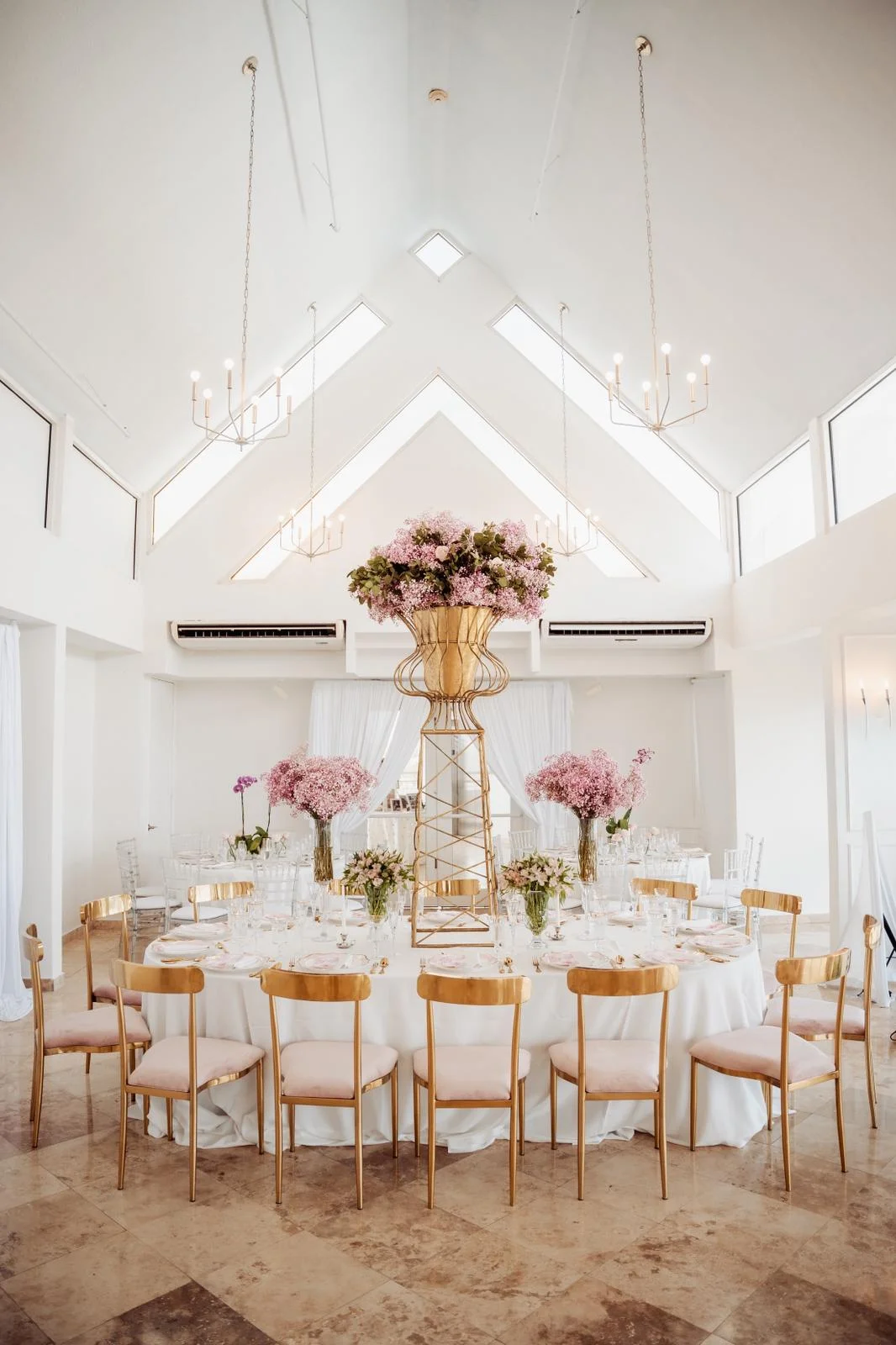 Salón luminoso con montaje de mesas y centro floral
