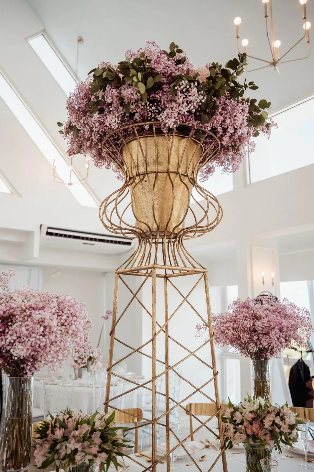 Centro de mesa alto con flores rosadas