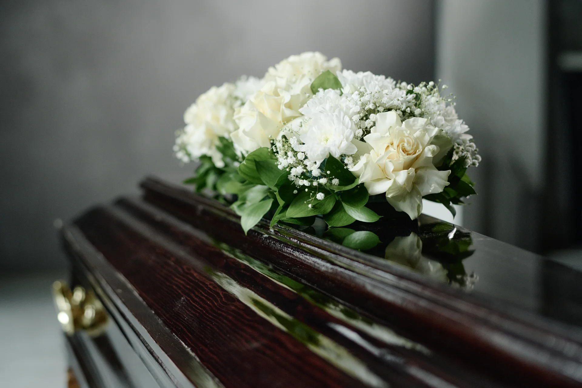 Servicio funerario con familia y arreglo floral