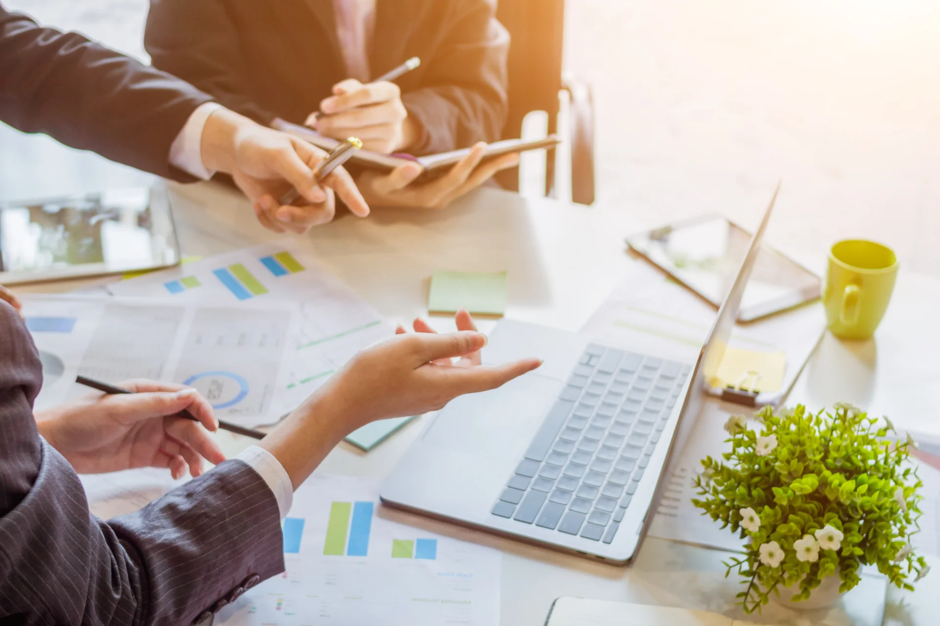 Profesionales coordinando una estrategia empresarial con gráficos y herramientas digitales