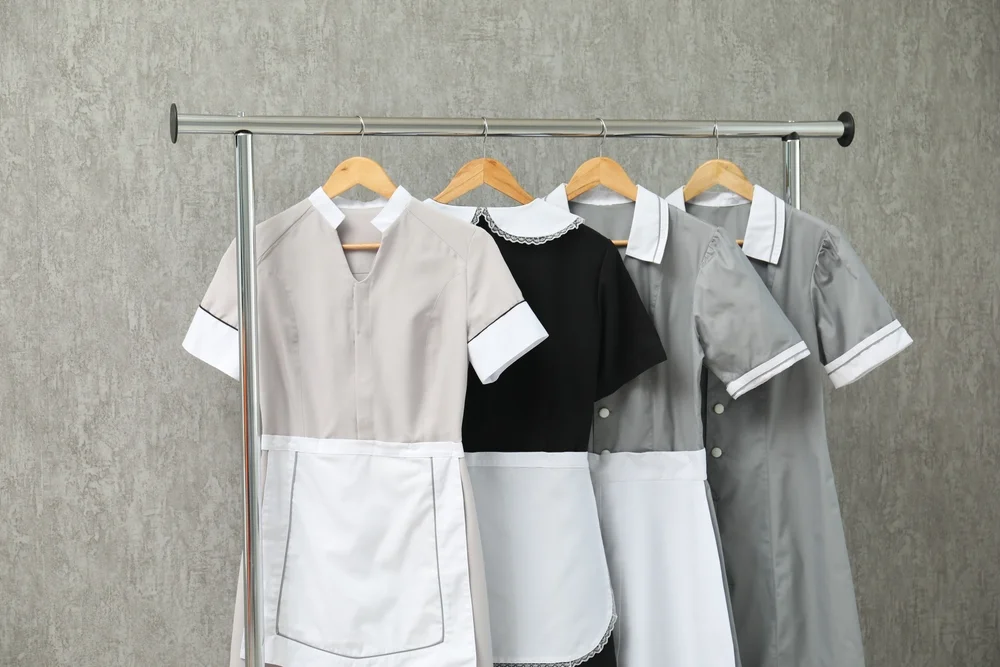 Uniformes de hotelería colgados en perchas